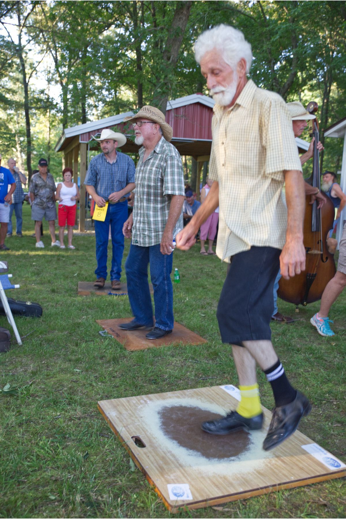 A man with a beard is standing on a wooden board