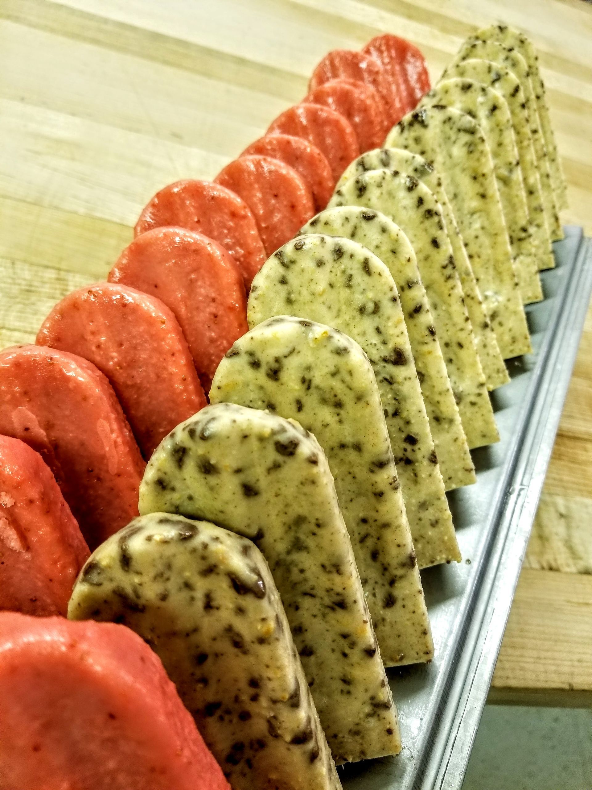 A bunch of different types of cookies are lined up on a tray