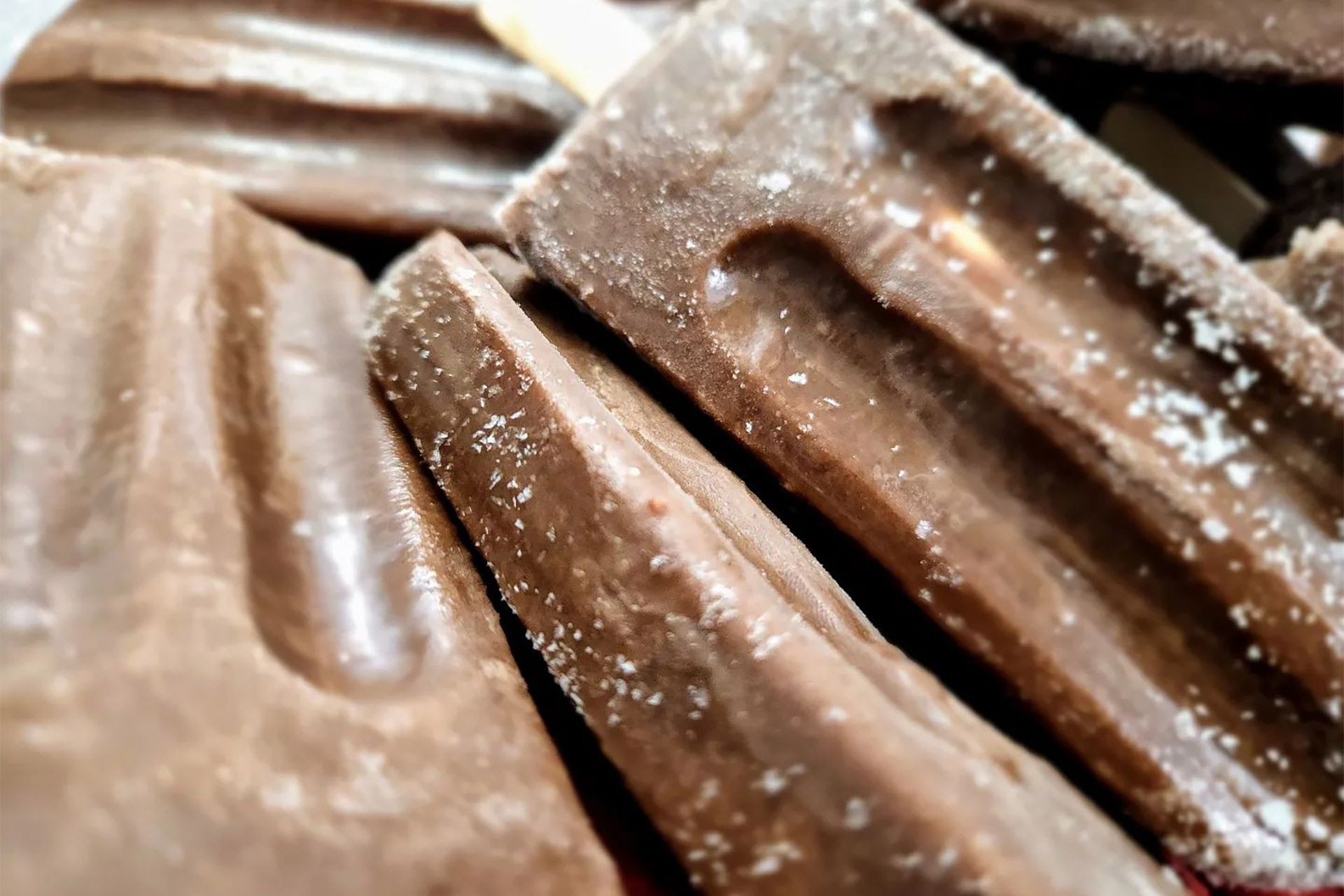A close up of a pile of chocolate covered popsicles