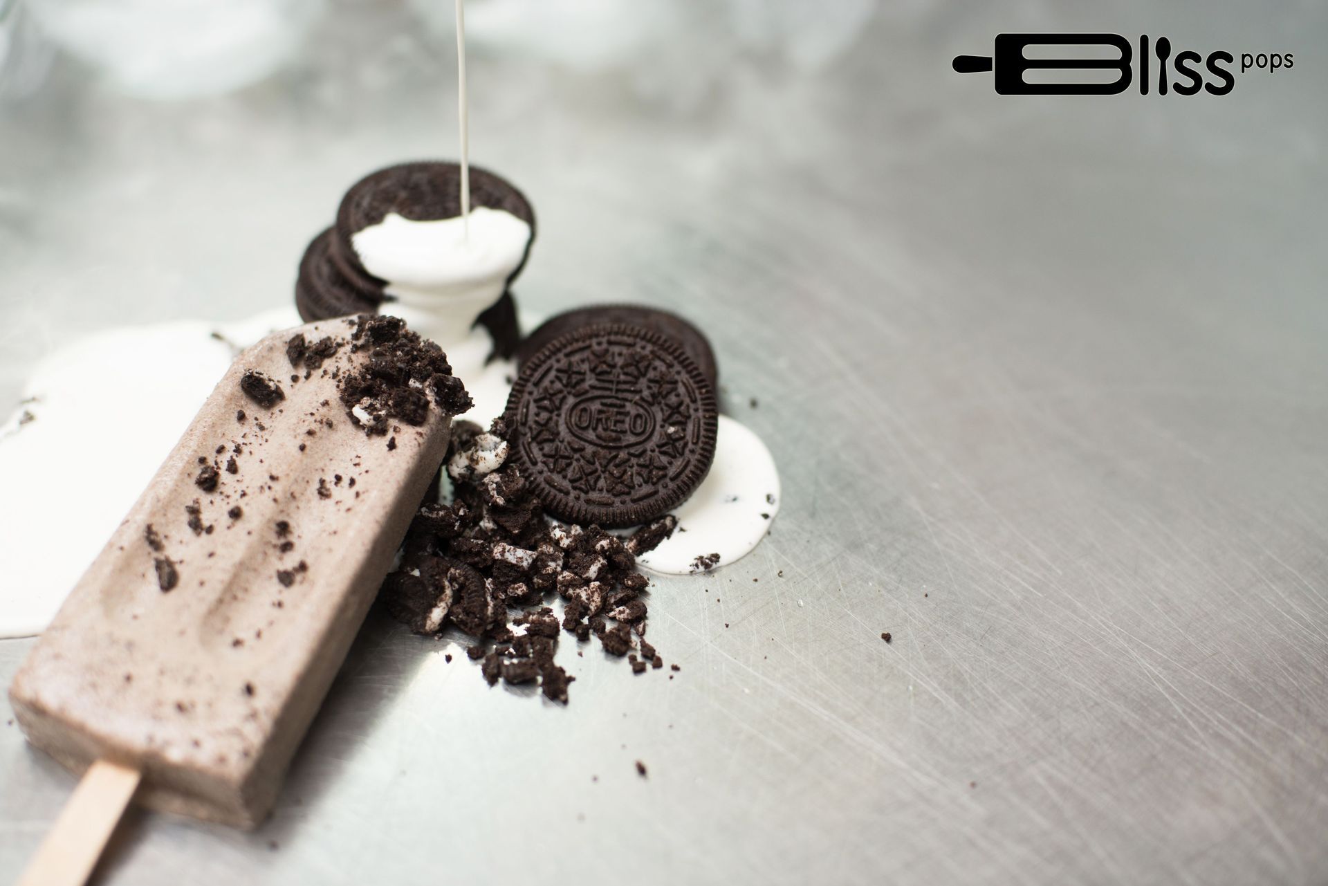A chocolate ice cream bar with oreos and milk on a table