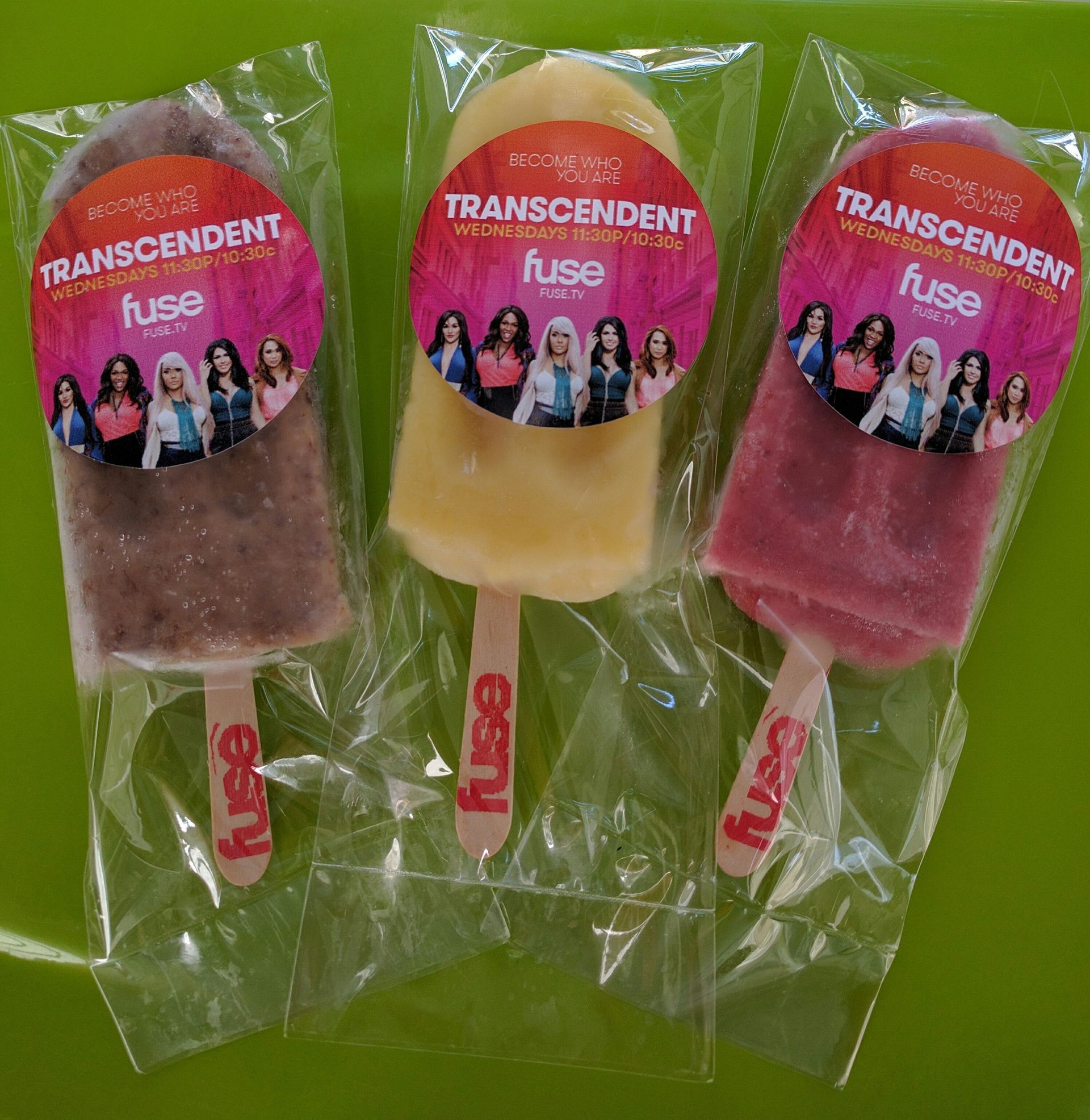 Three fuse popsicles are sitting on a green table