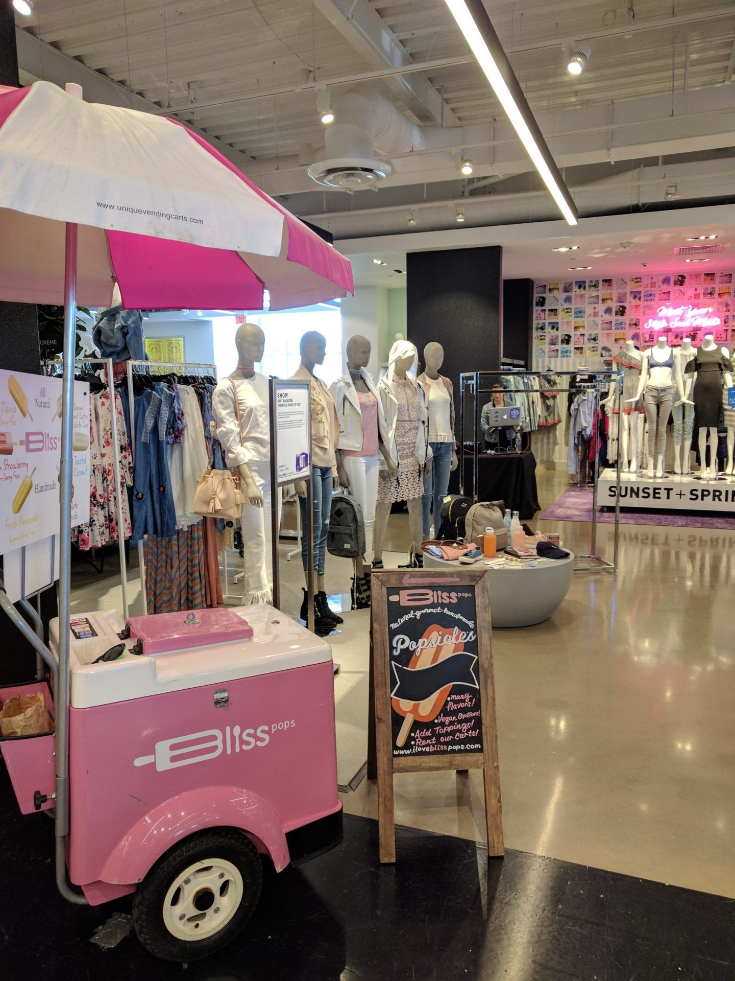 A pink and white ice cream cart in a store