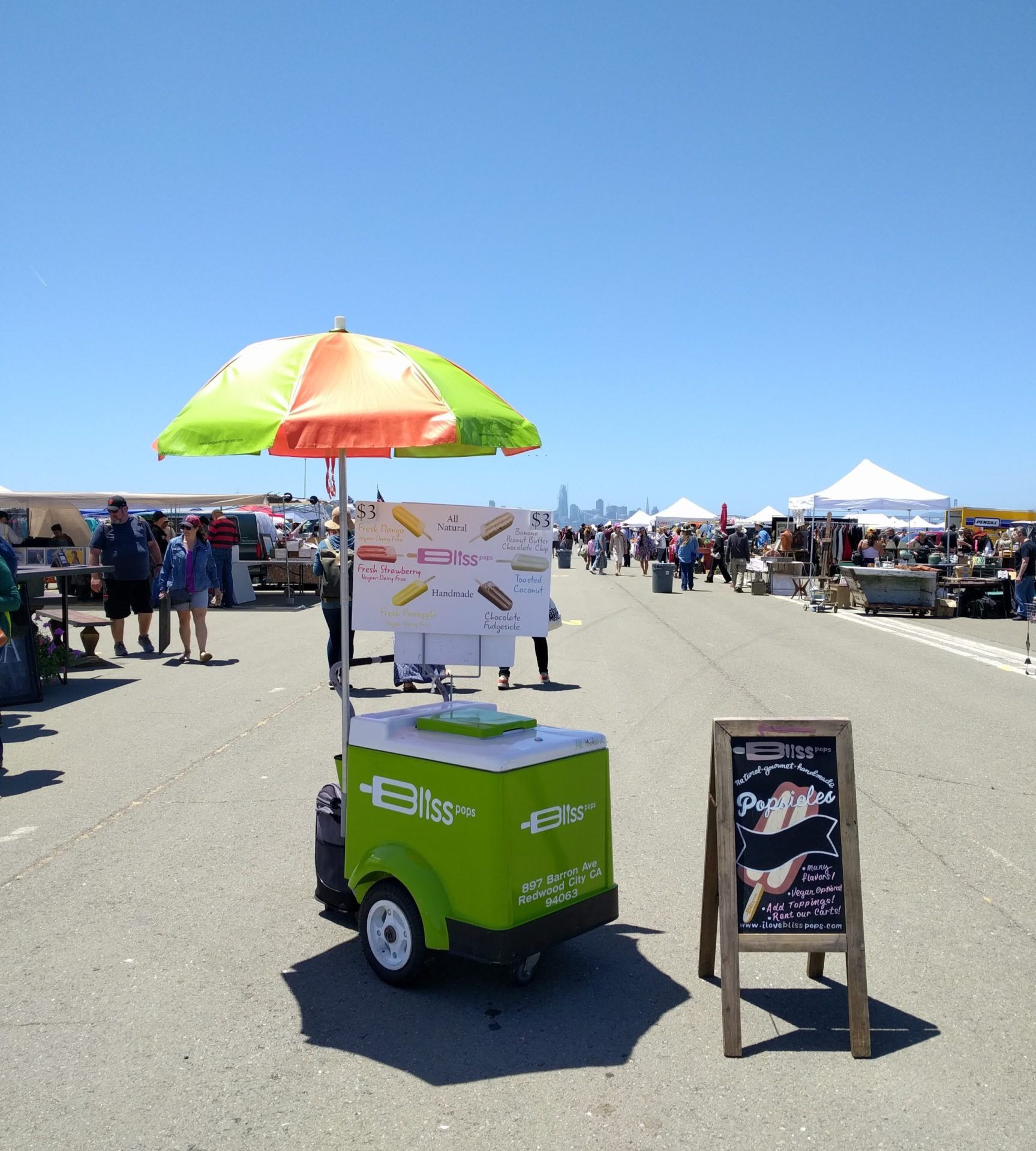 A green cart with a sign that says ' ice cream ' on it