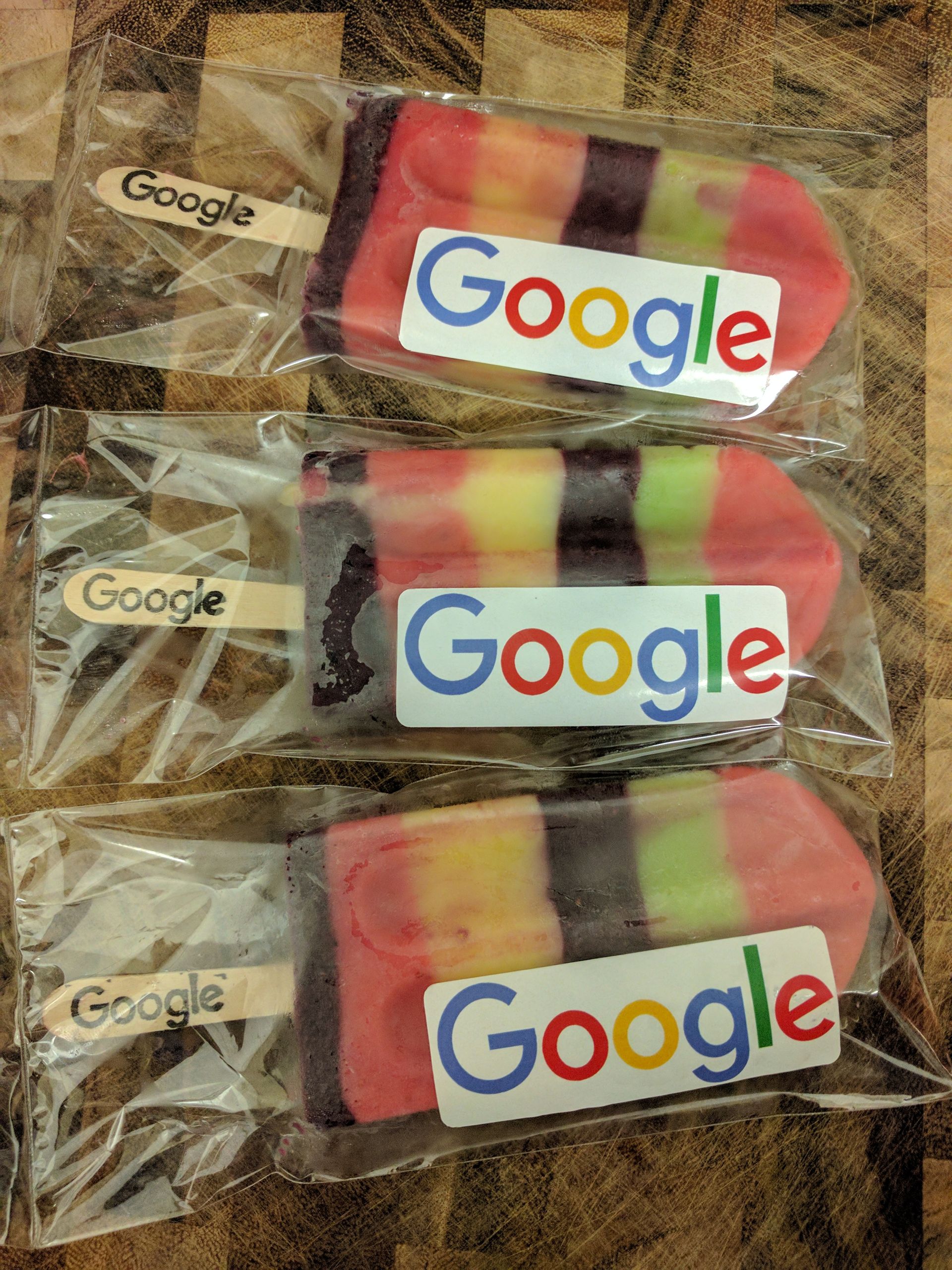 Three google popsicles are wrapped in plastic