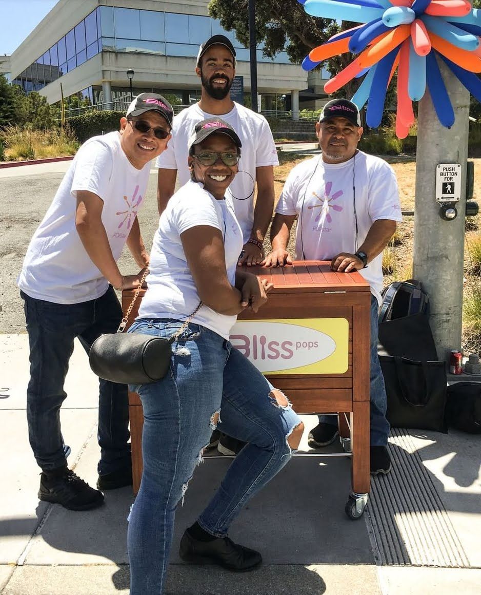 A group of people standing around a box that says bliss