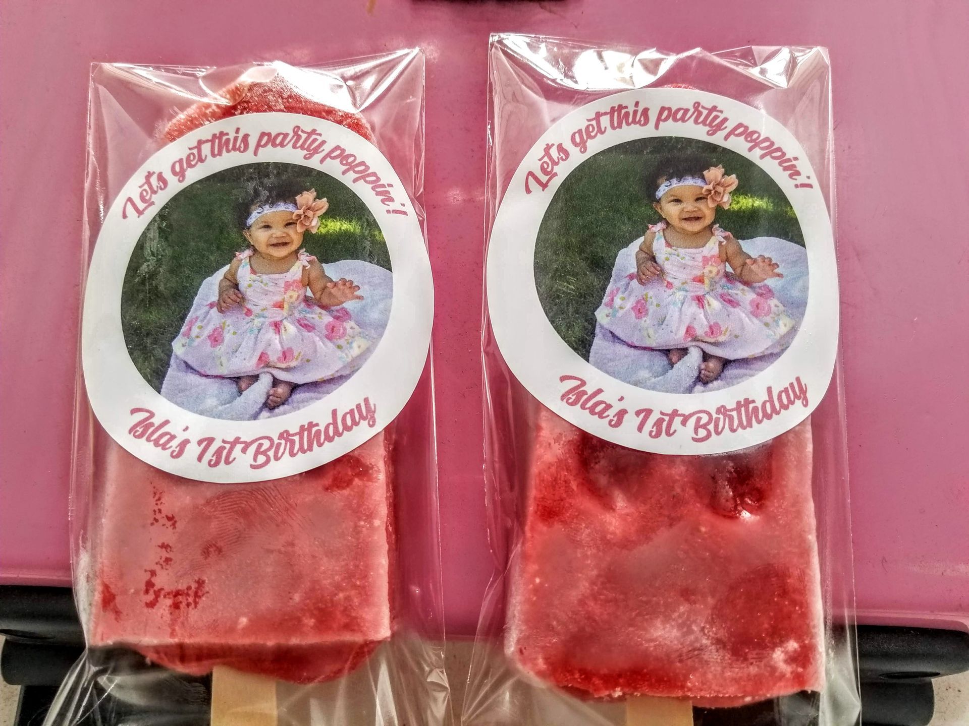 Two ice pops with a picture of a baby on them.