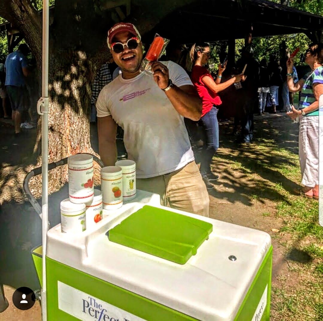 A man holding a popsicle in front of a perfect cooler