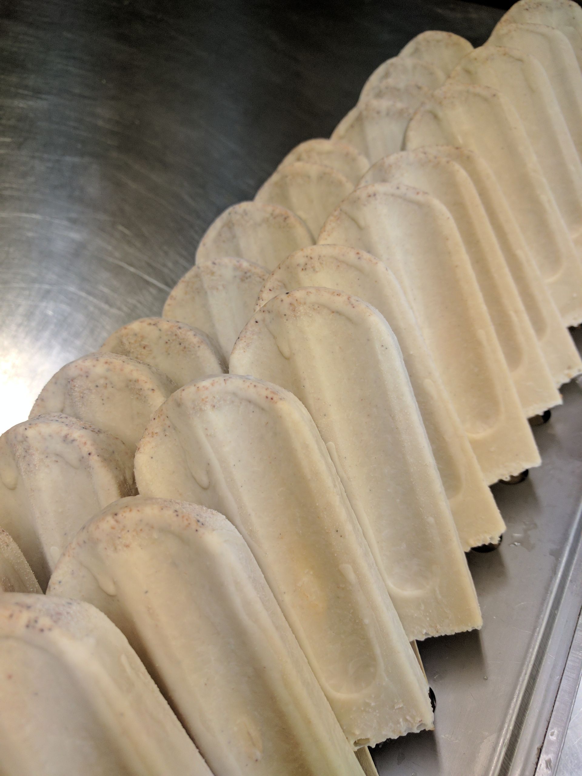 A bunch of ice cream bars are lined up on a tray