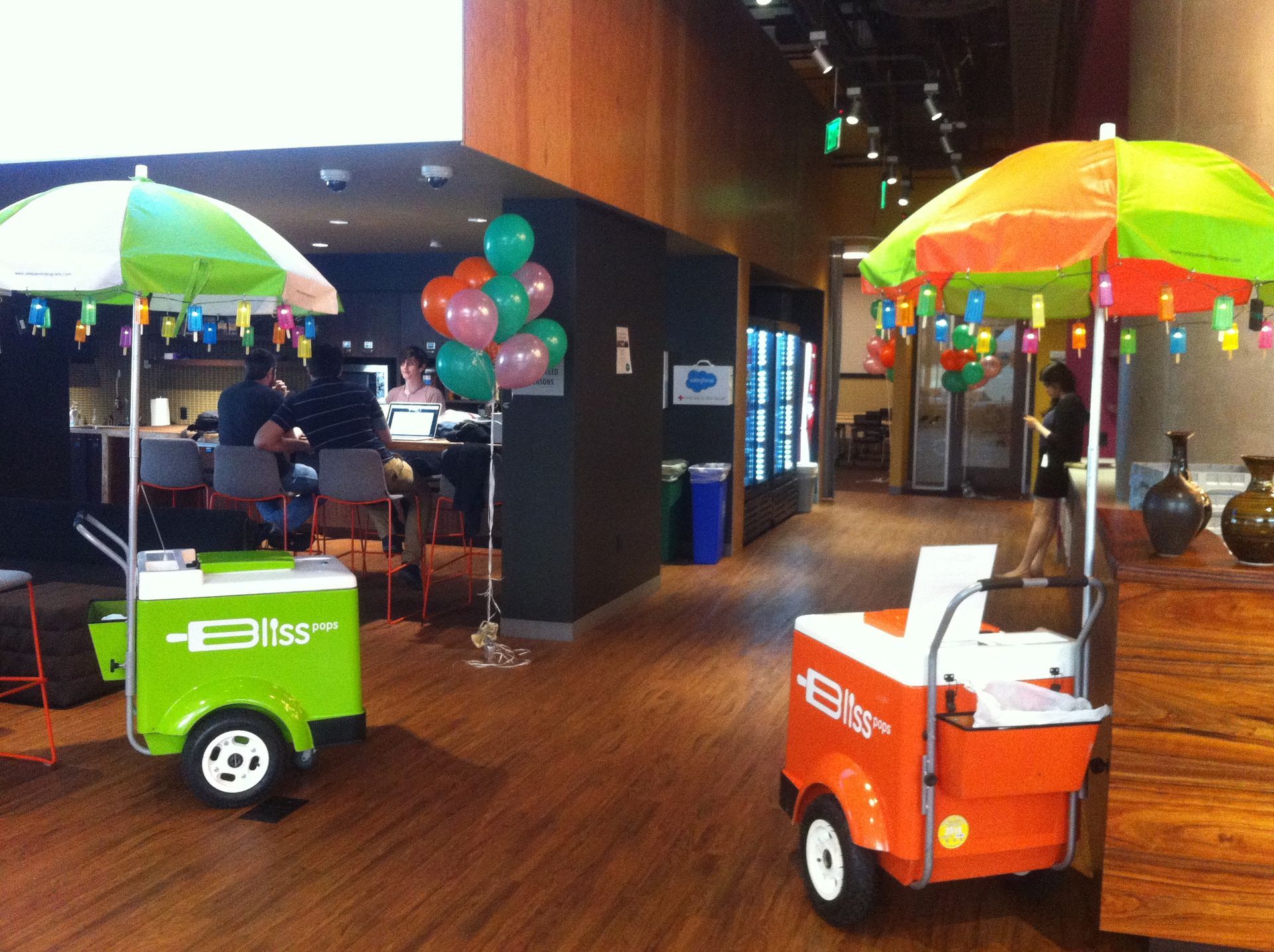 Two ice cream carts with umbrellas in a room