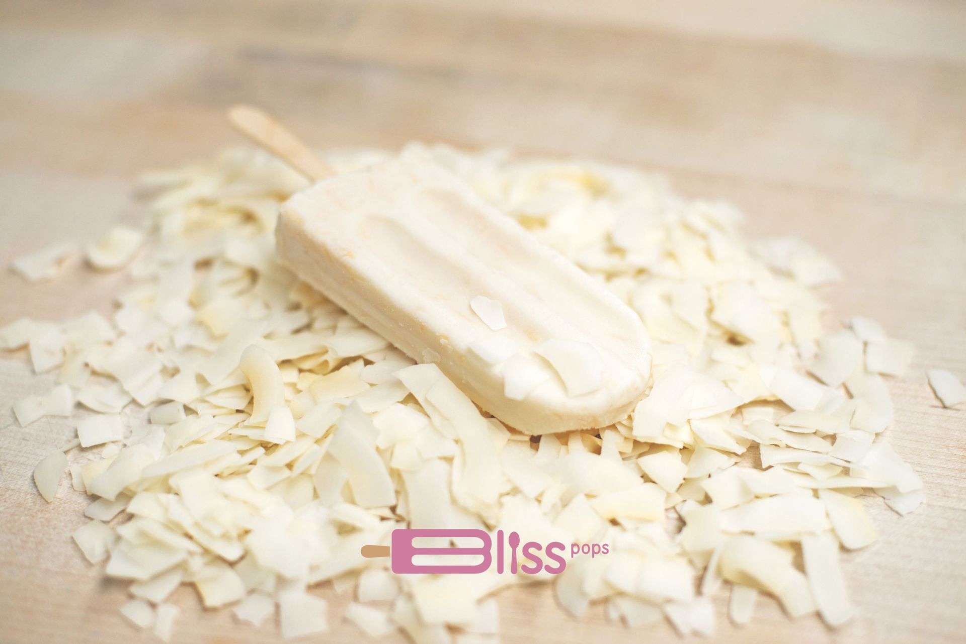 A popsicle is sitting on top of a pile of coconut flakes.