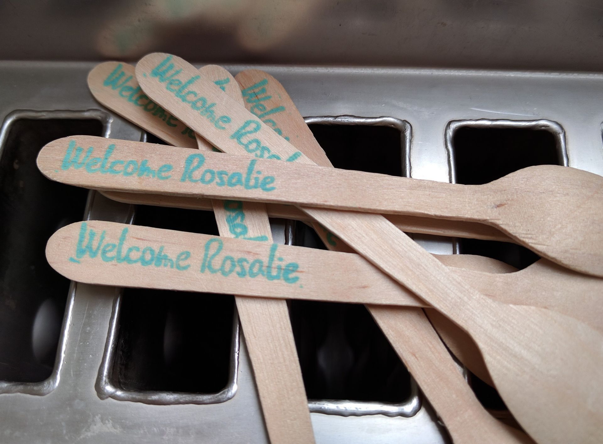 A bunch of wooden spoons with welcome rosalie written on them