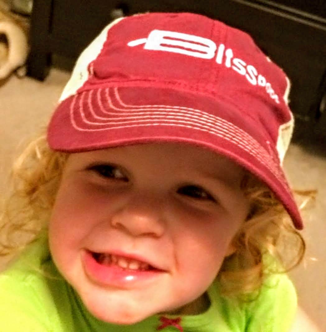 A little girl wearing a hat that says bliss on it