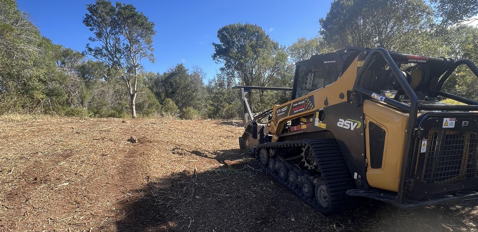 A Yellow and Black Tracked Machine Clearing a Brown Field With Trees — Dudgeon’s Earthworks in Murgon, QLD