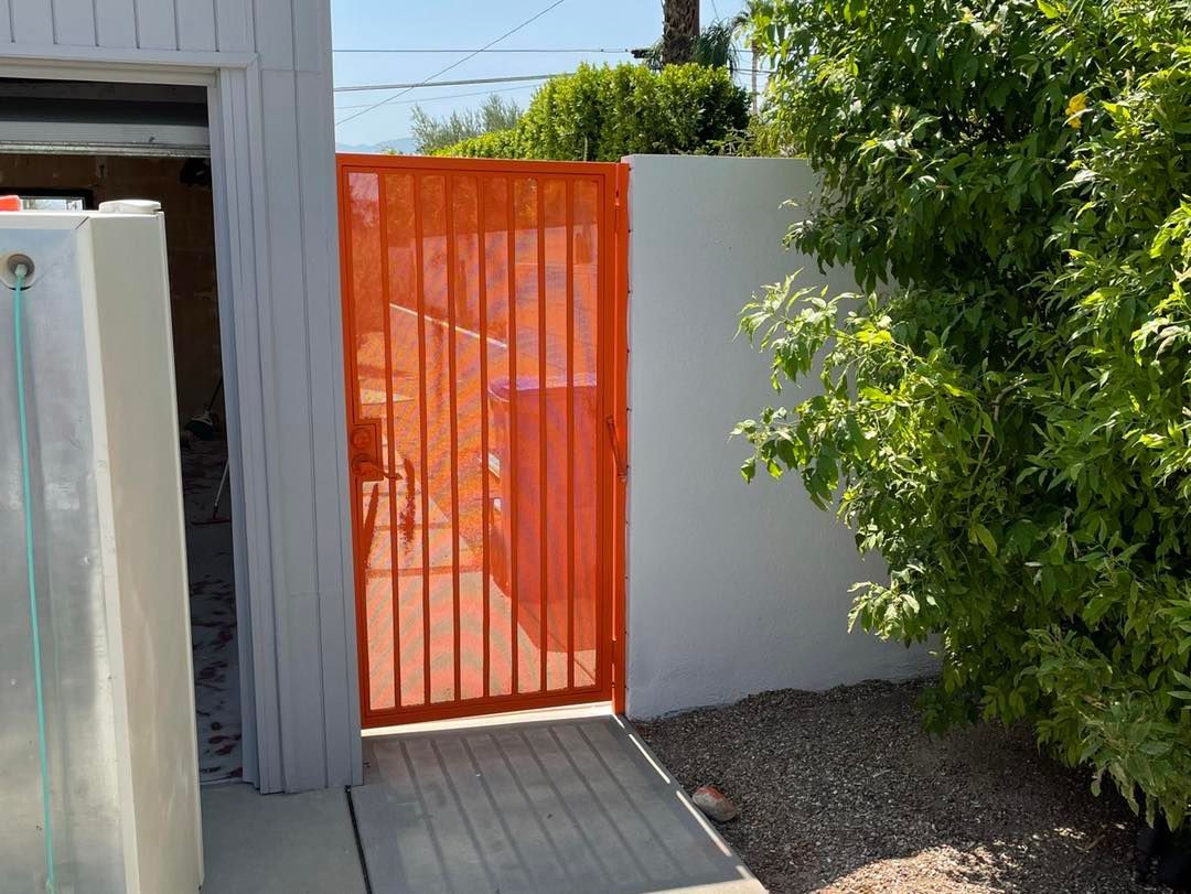 Picture of a gate painted in a brilliant orange color.