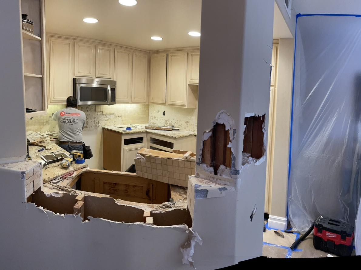 Image of a kitchen that is in the process of a kitchen remodel. The countertops are being replaced and the cabinets are being refaced. 