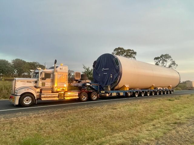 A Large Truck Transporting a Long, Cylindrical Structure on a Highway — ECC Heavy Haulage in Ormeau, QLD