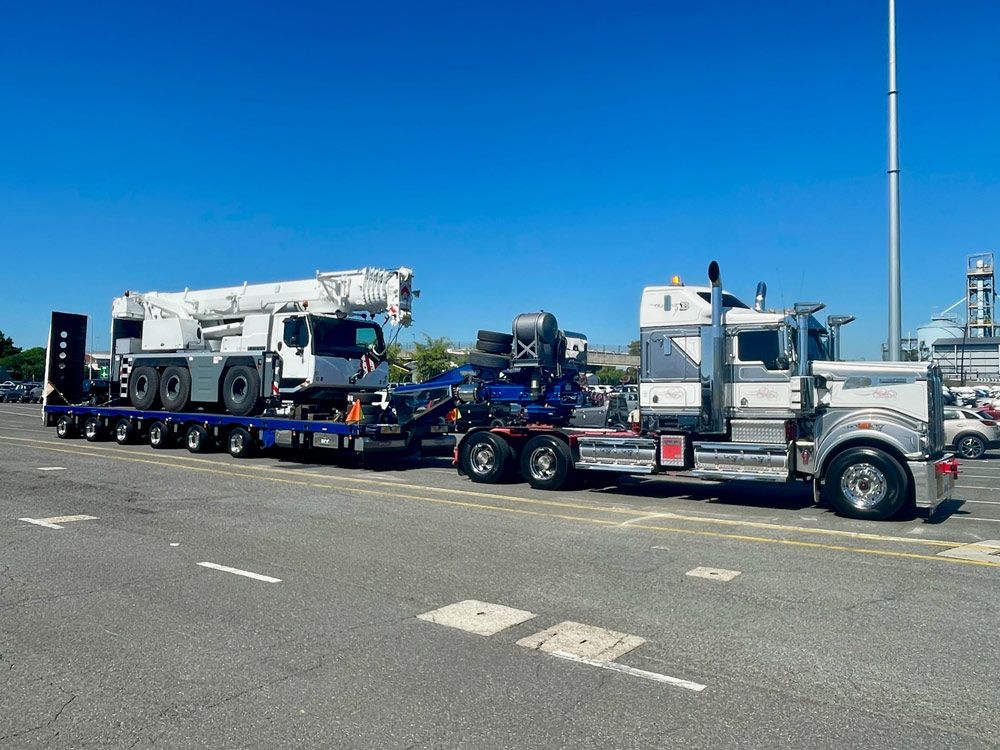 A Semi-truck Towing A Crane On A Flatbed Trailer — ECC Heavy Haulage in Ormeau, QLD