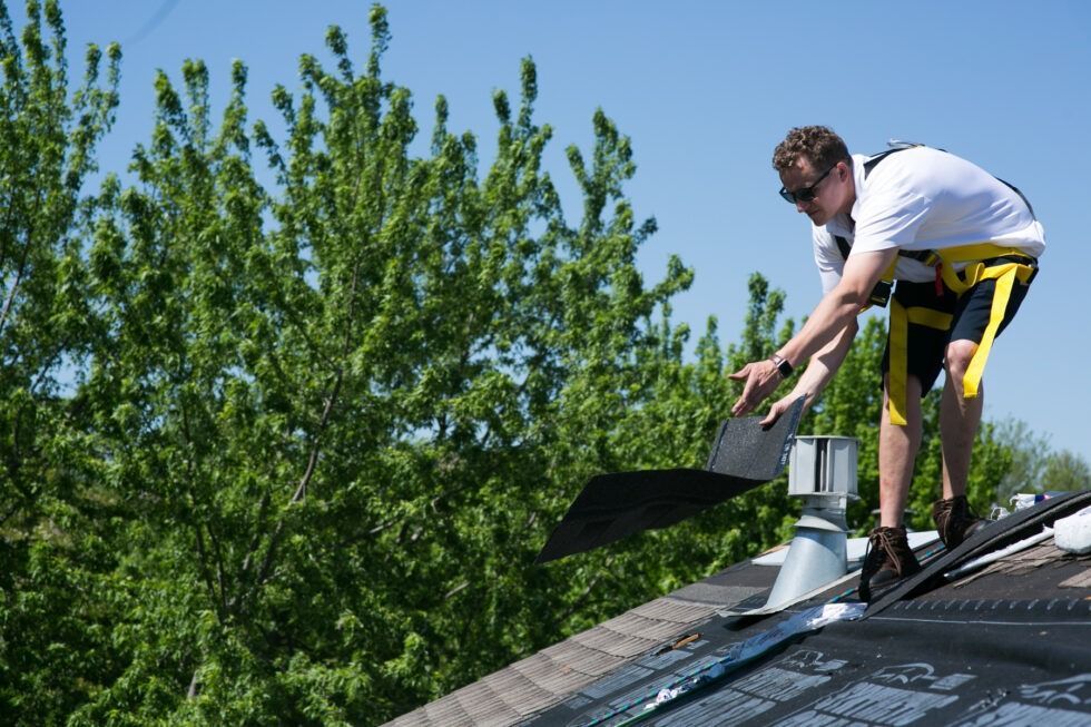 A man is working on the roof of a house.