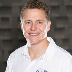 A man in a white shirt is smiling for the camera.