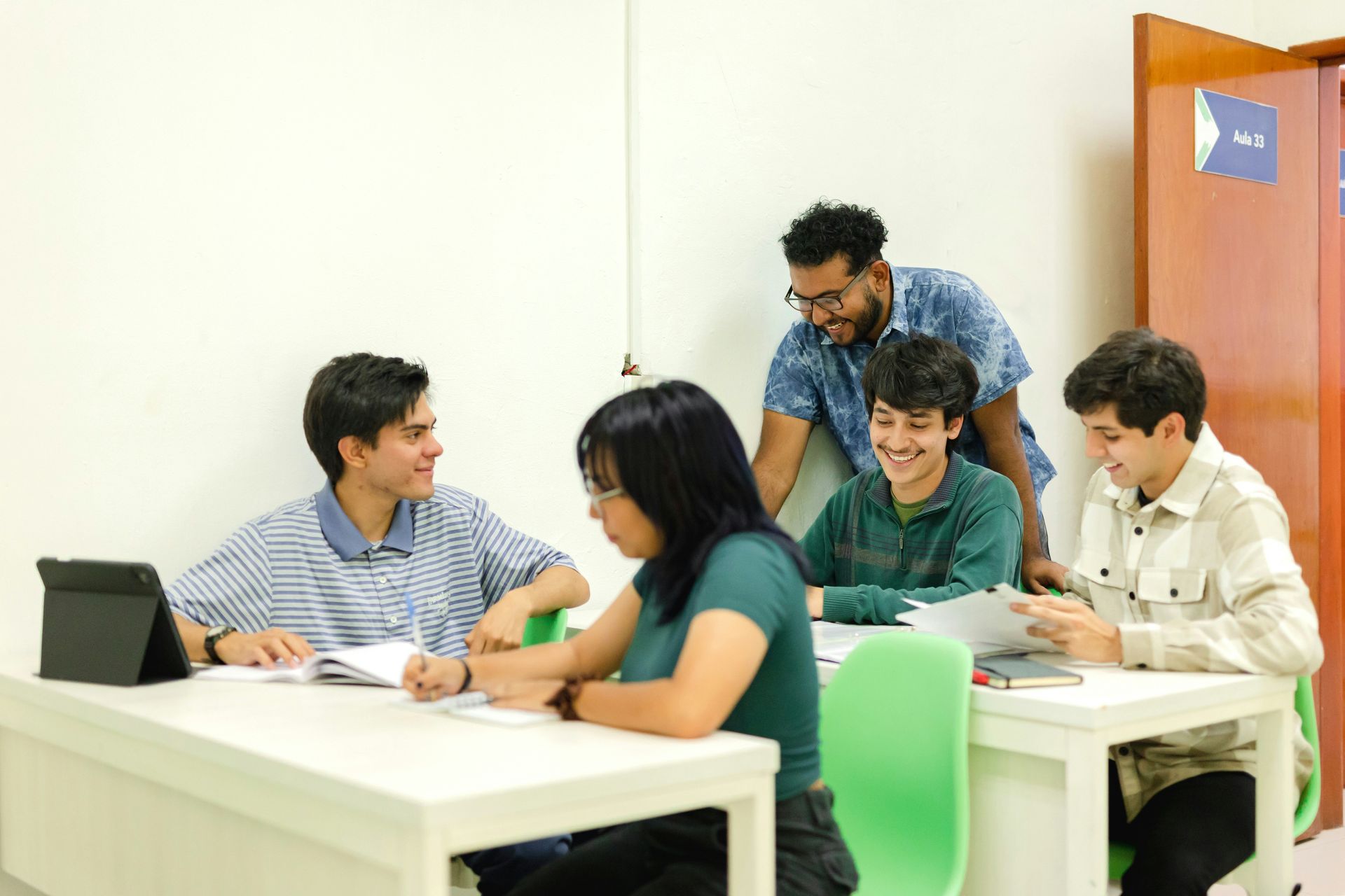 Group of students collaborating and studying together at desks in a classroom
