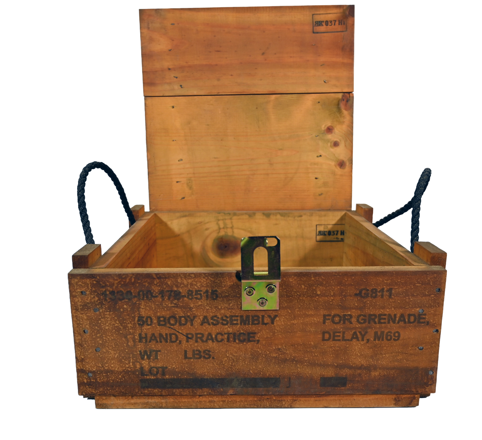 Wooden box on a green table with a military vehicle and guard tower in the background.
