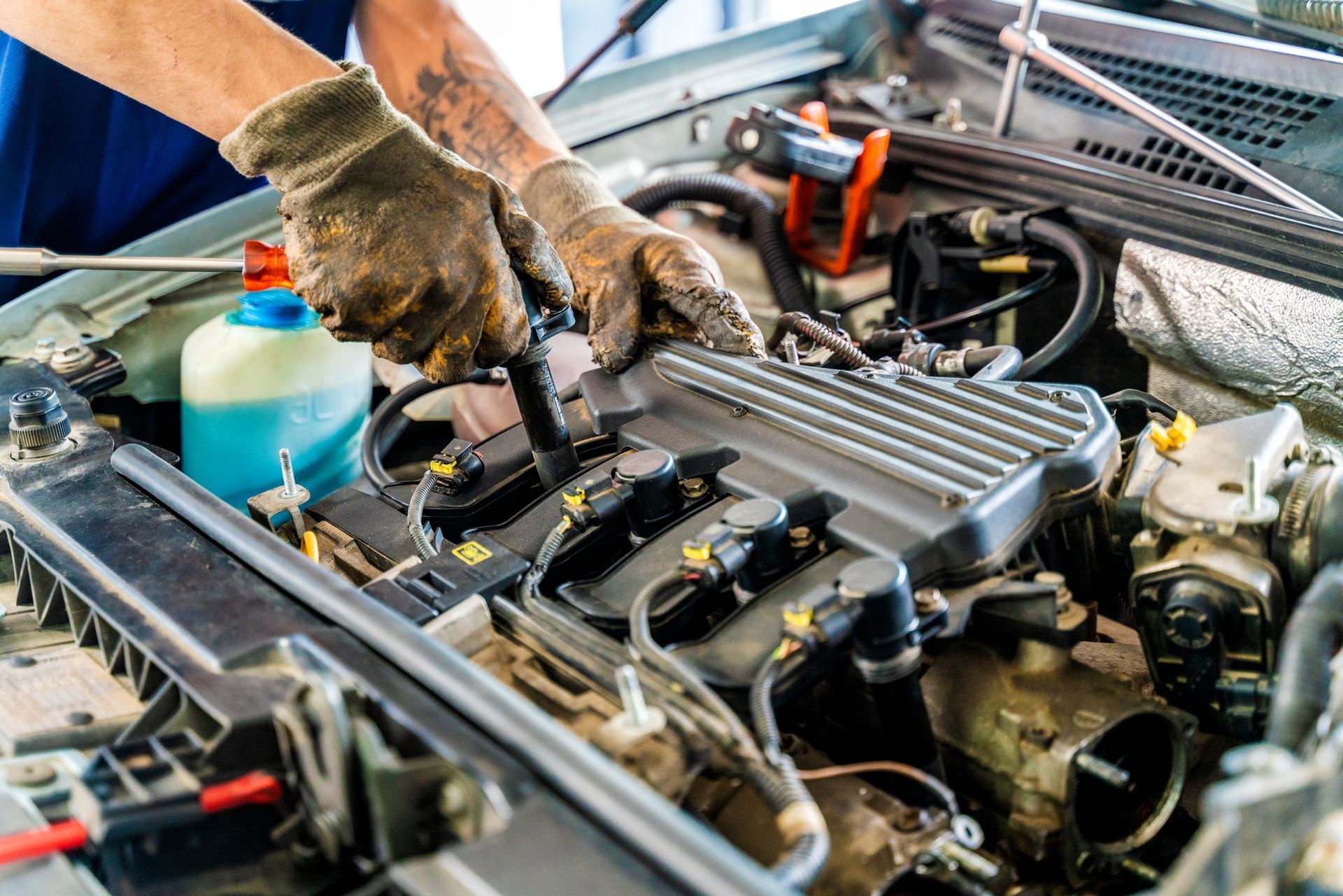 A man is working on the engine of a car.