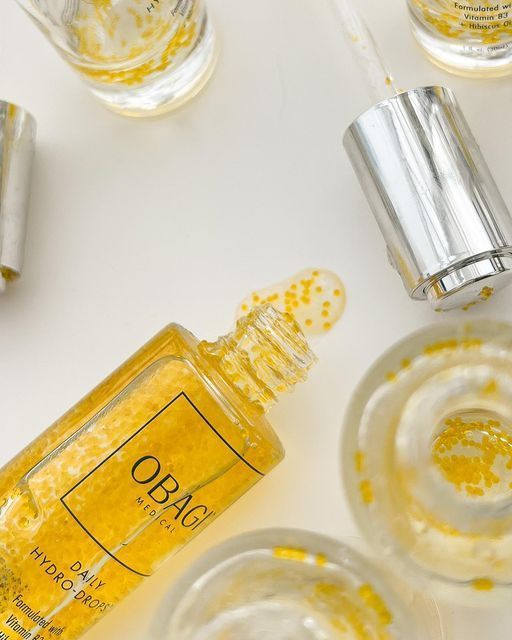 Yellow O Boticário perfume bottle with silver caps on a white surface, viewed from above