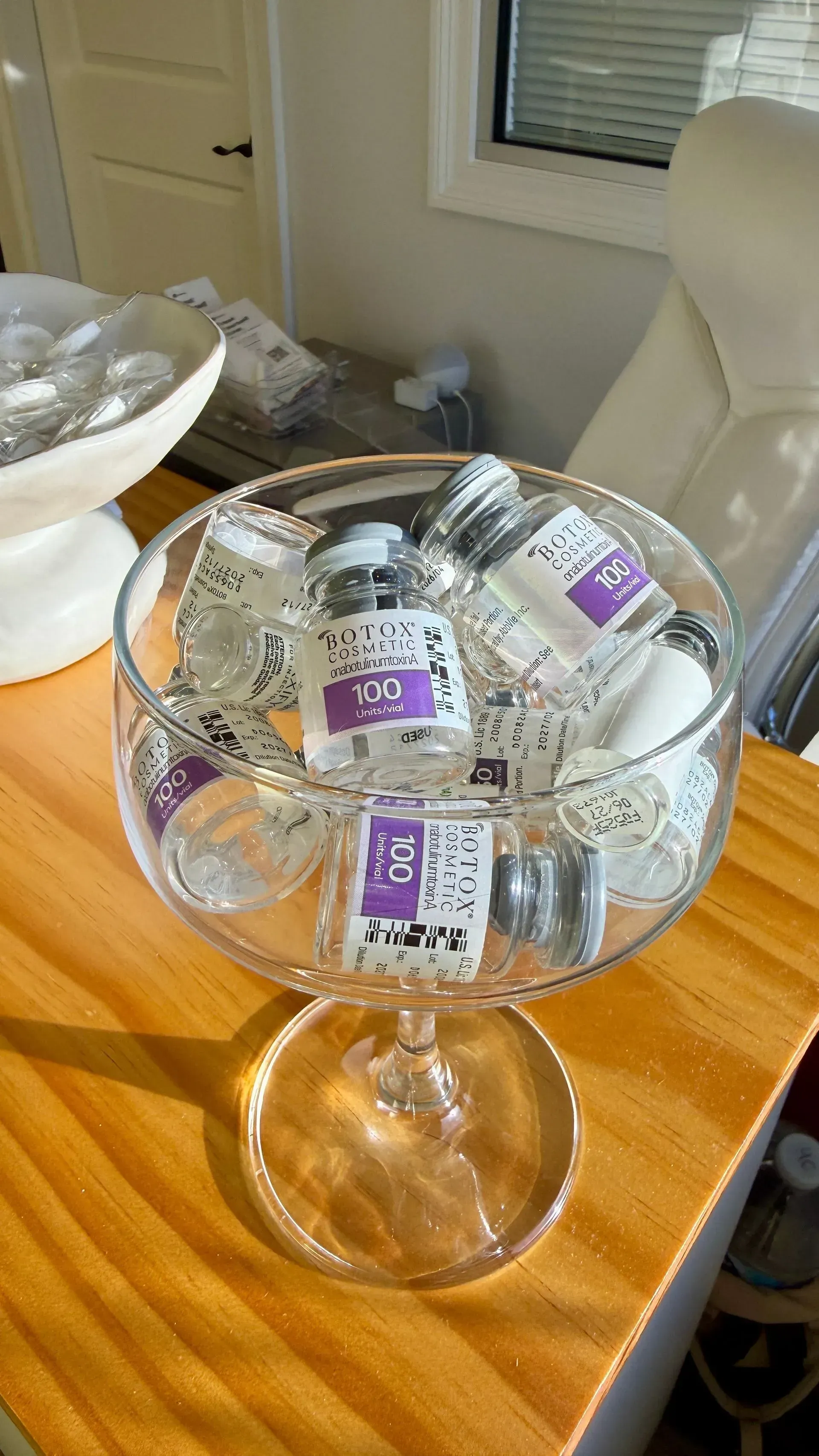 Glass bowl on a wooden table filled with small purple-and-white wrapped candies