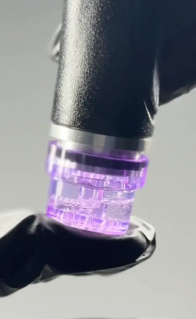 Gloved hand holding a black pen with a glowing purple translucent tip against a light background