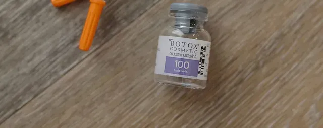 Small Botopia bottle with a purple label on a wooden surface, next to an orange plastic piece.