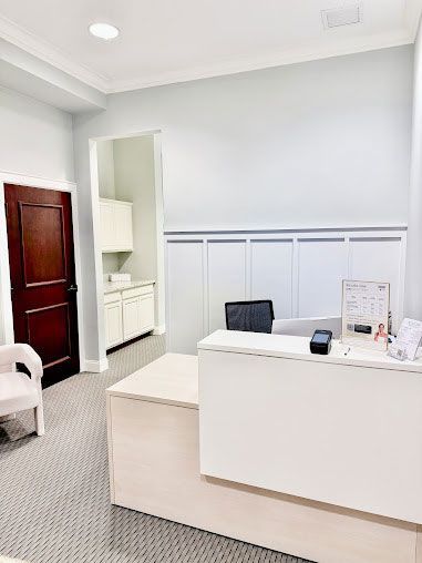 Cozy spa treatment room with massage table, rolled white towel, warm lamp, and wooden storage cabinets