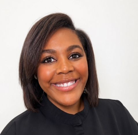 Smiling person in a black top against a white background
