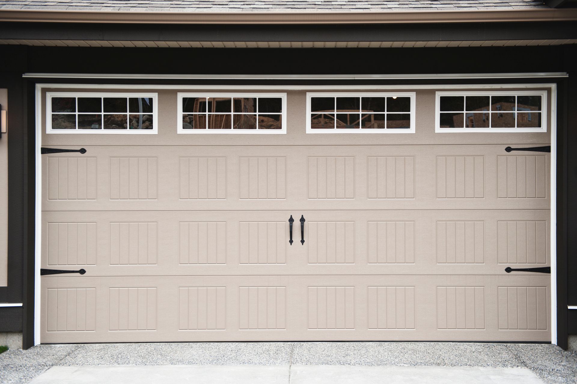 A garage door with decorative windows and a crisp white trim, adding charm to the residential facade