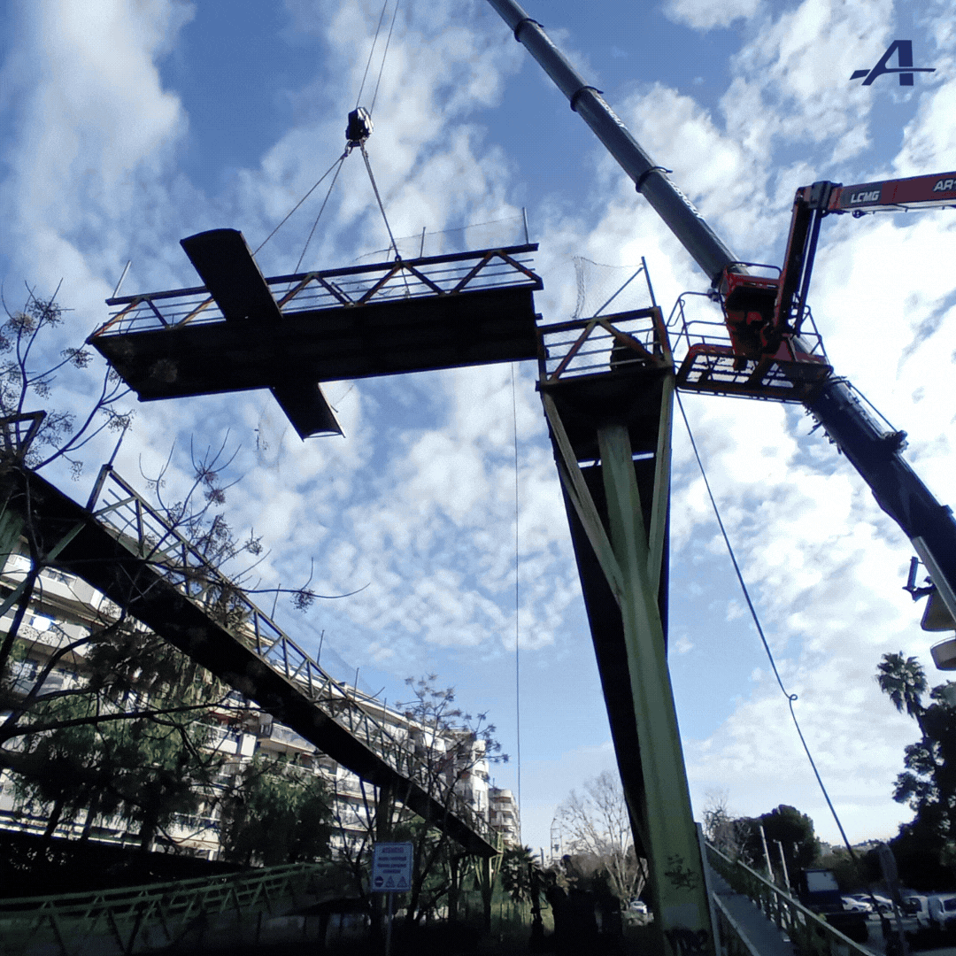 Una grúa está levantando un puente con la letra a encima.