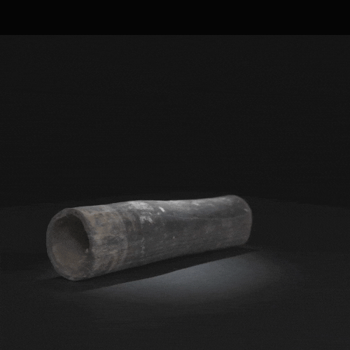 Una tubería negra está asentada sobre una superficie negra en la oscuridad.