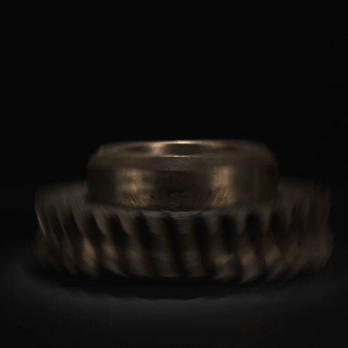 Un primer plano de un engranaje de metal sobre un fondo negro.