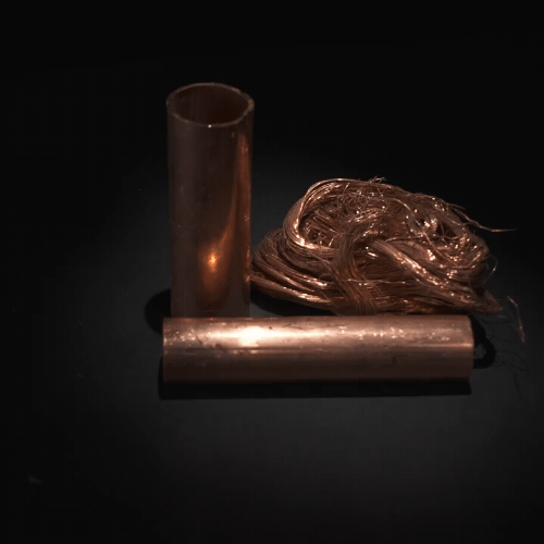 Un montón de tubos y cables de cobre están sobre una mesa.