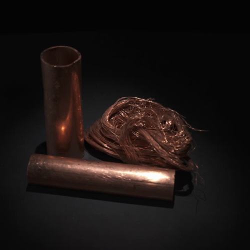Un montón de tubos y cables de cobre están sobre una mesa.