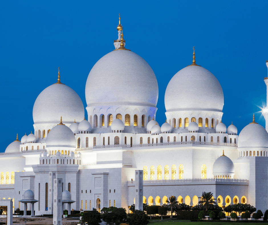 A large white mosque with a blue sky in the background