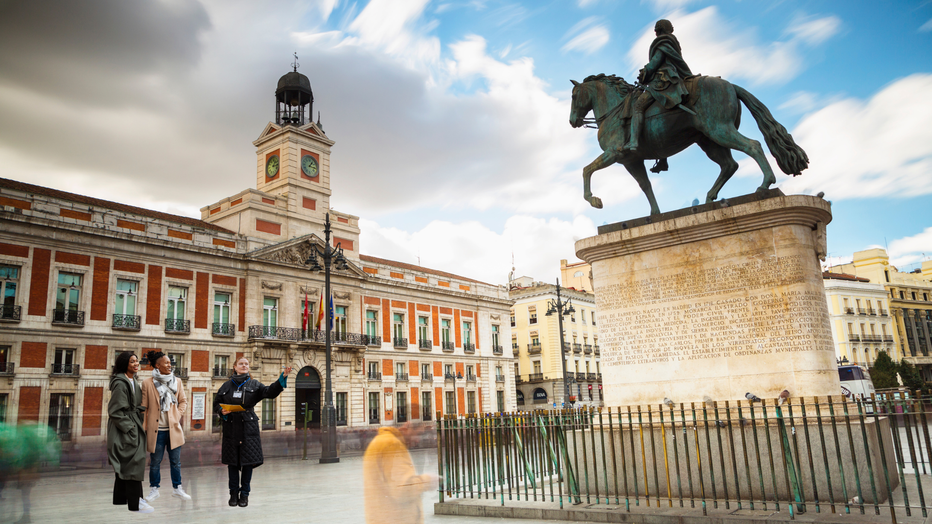 Plaza del Sol in Madrid, Spain. Statue of a man on a horse, historic building, group of people.