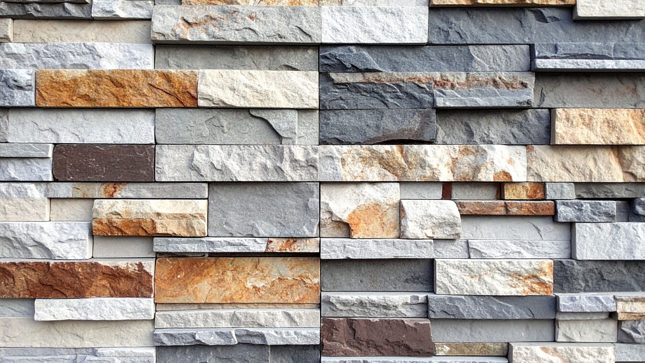 Stone wall with rectangular, multi-colored blocks.