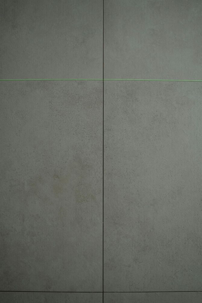 Close-up of gray tiled surface with thin, dark grout lines.