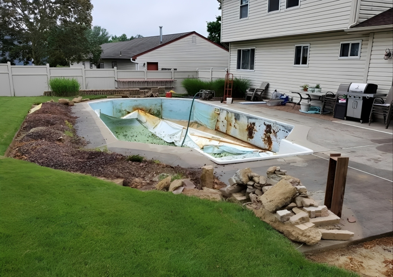 Backyard swimming pool with blue water, concrete deck, and trees beside a house