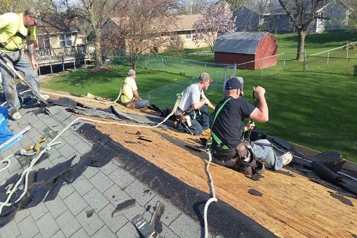 A group of men are working on a roof.