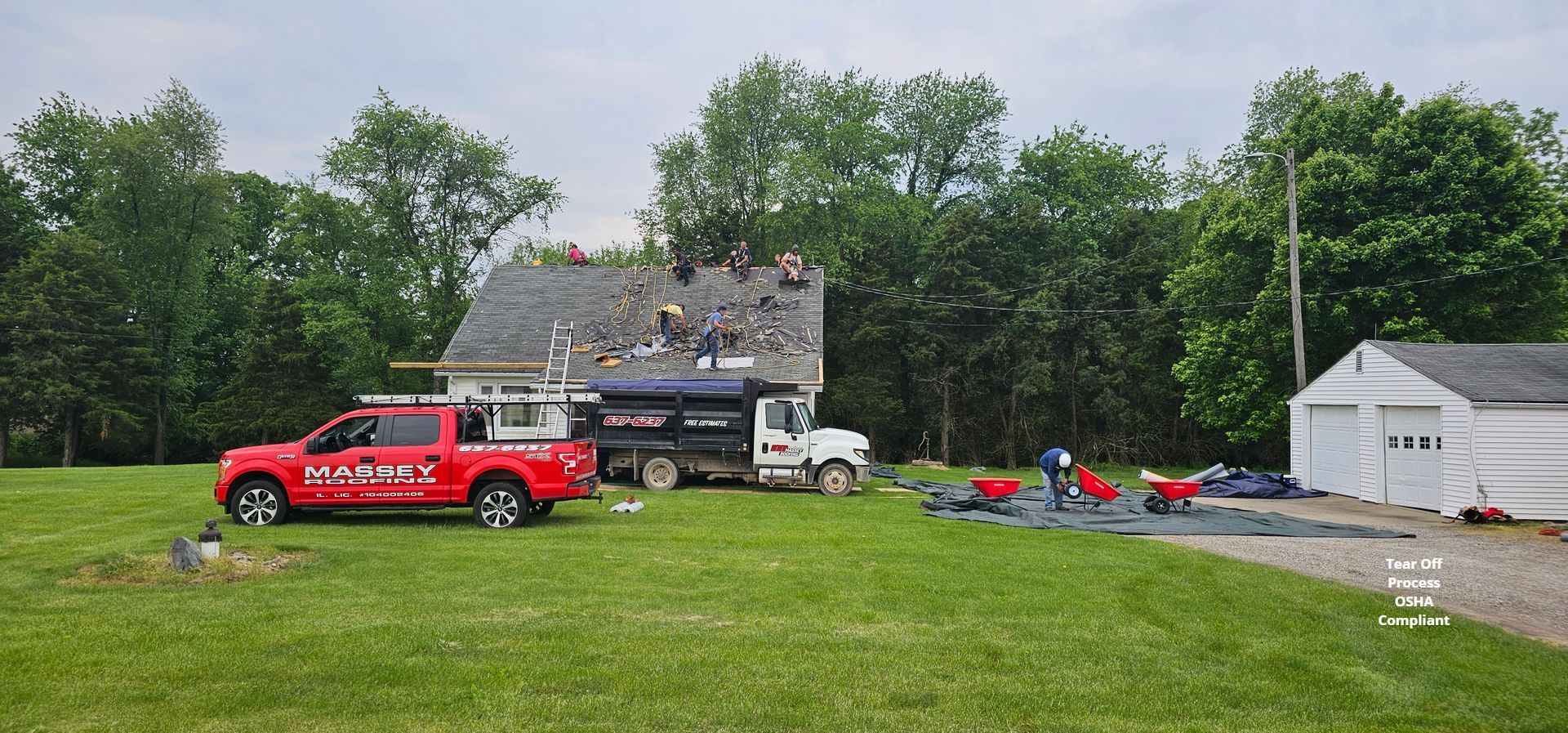 A red truck is parked in a grassy field in front of a house.