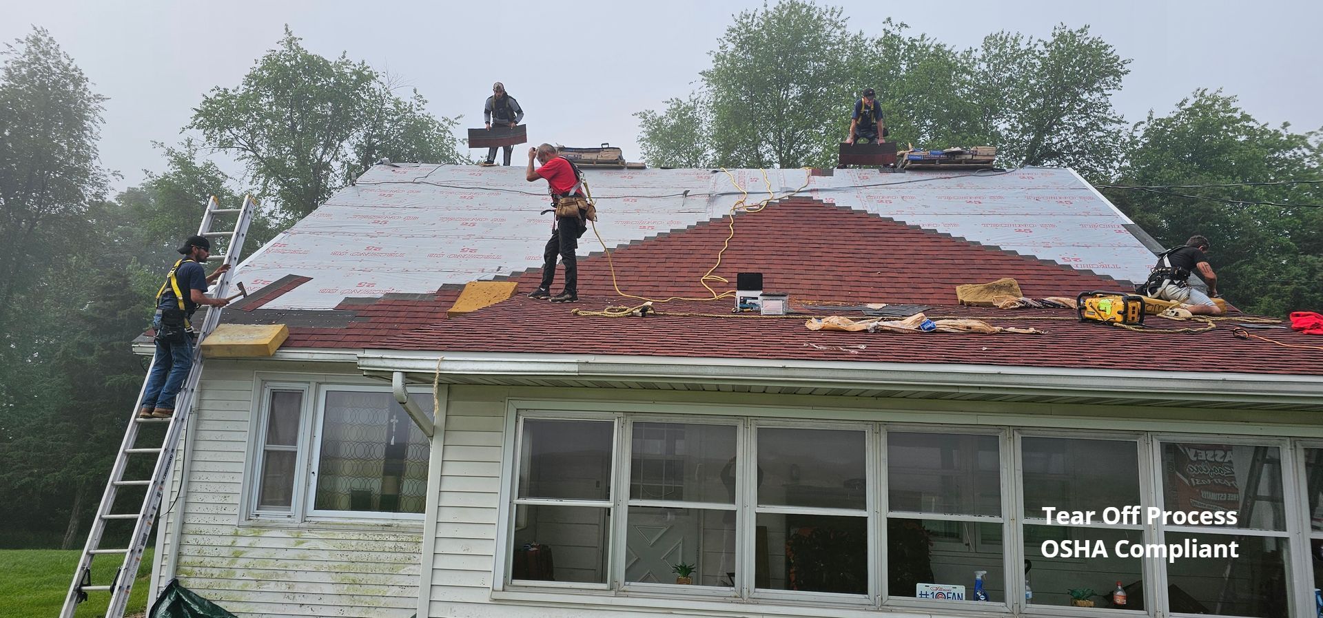 A group of people are working on the roof of a house.