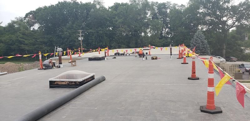 A construction site with a lot of cones and flags.