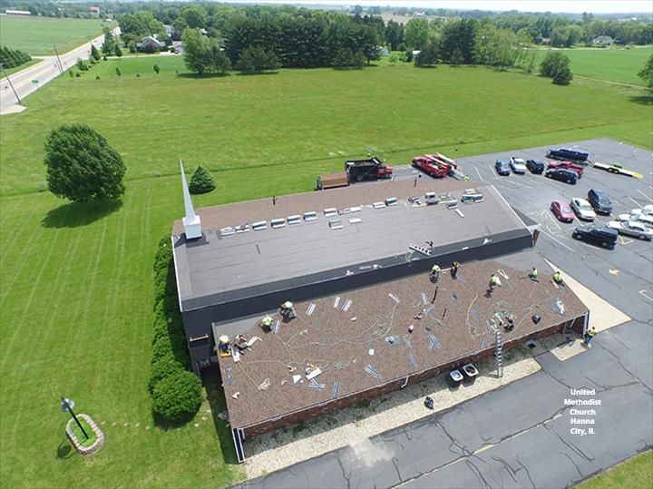 An aerial view of a church with a roof that is being repaired.