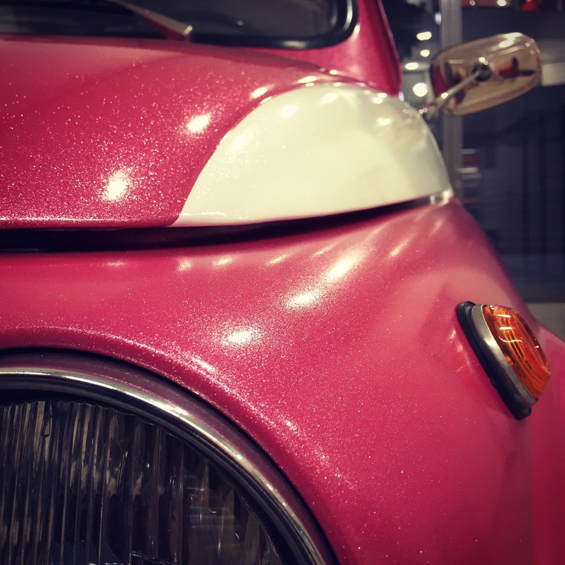 Pink vintage car with white accent, headlight and side mirror. Fiat 500 Ultra Metallic.