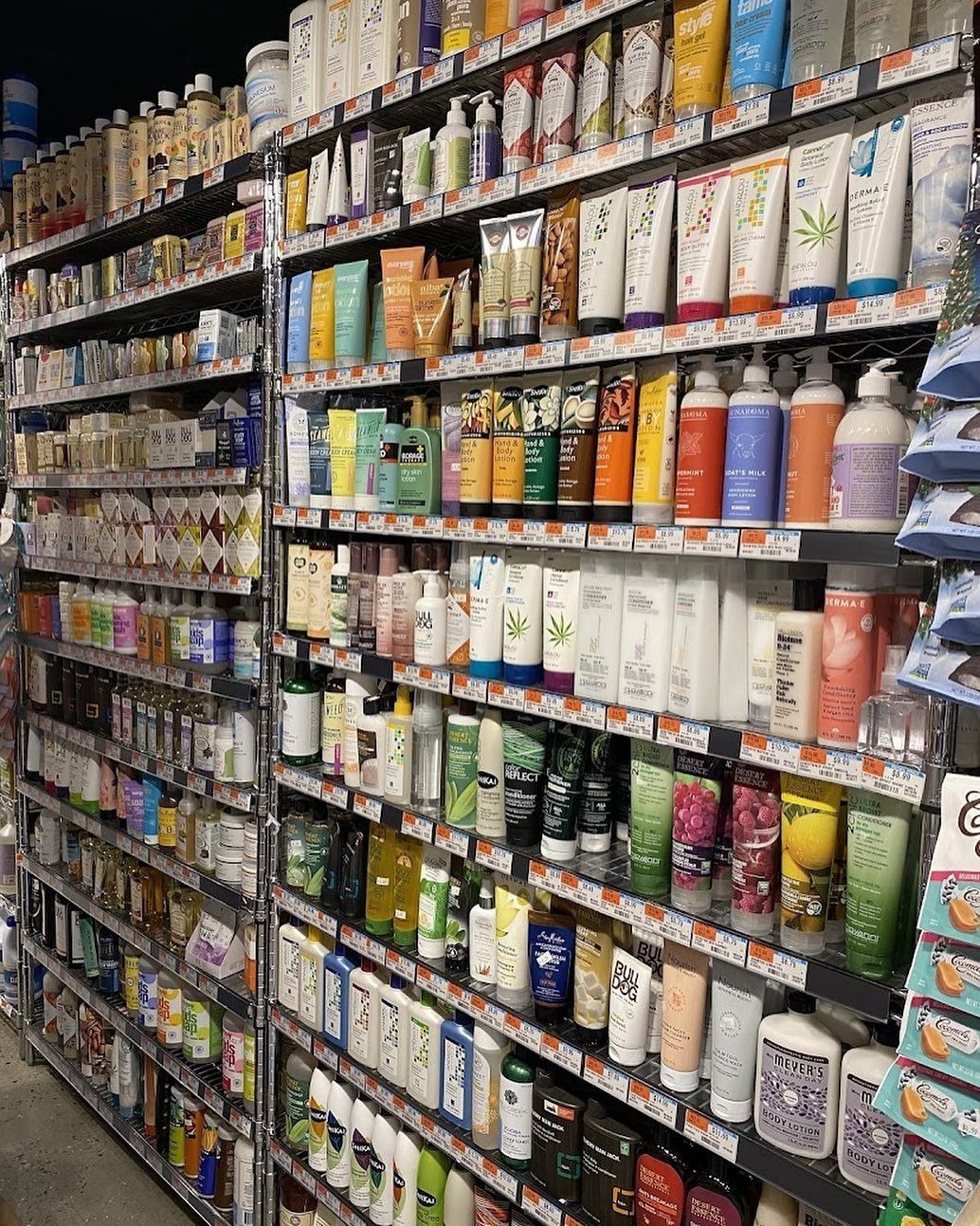 A grocery store aisle stocked with rows of colorful canned and bottled goods on tall shelves.